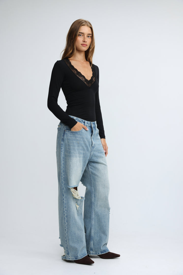 Mysterious black shirt with long sleeves and delicate lace trim at the neckline shown from the front