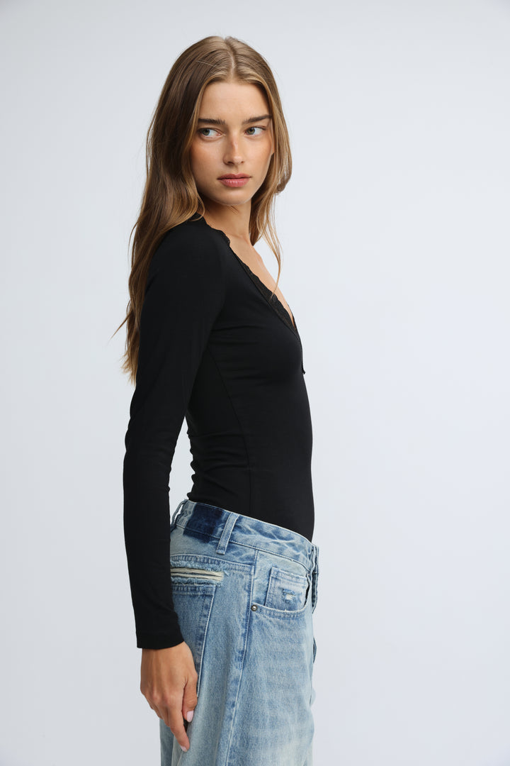 Black long-sleeved shirt with subtle v-neckline and fitted silhouette shown from the front in the mysterious black shirt