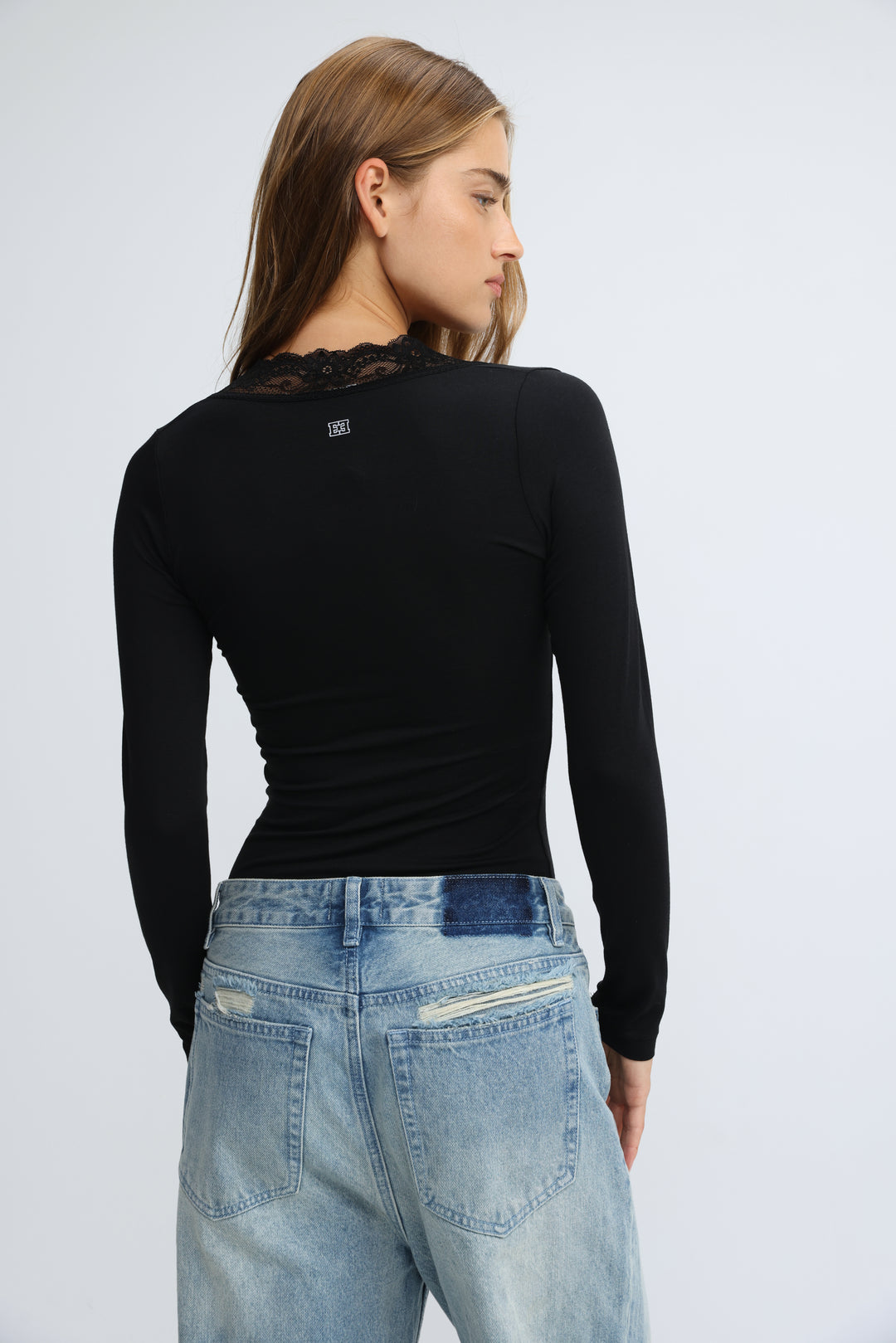 Black long-sleeved top with lace detailing at the neckline shown from the front called mysterious black shirt
