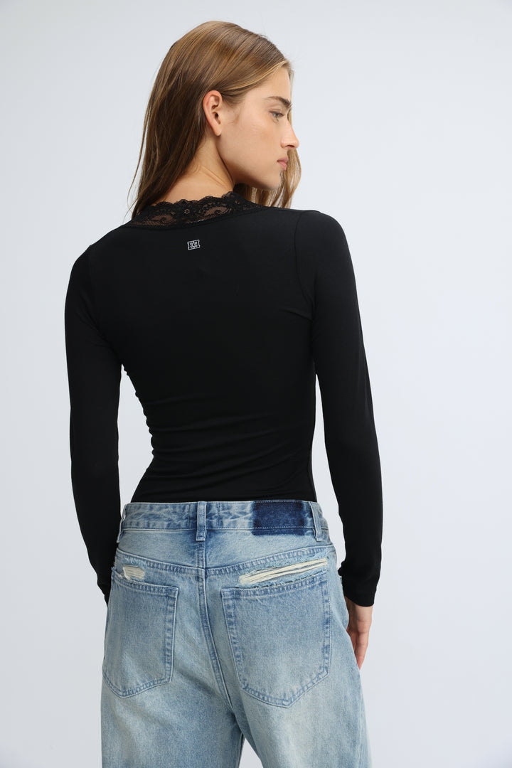 Black long-sleeved top with lace detailing at the neckline shown from the front called mysterious black shirt