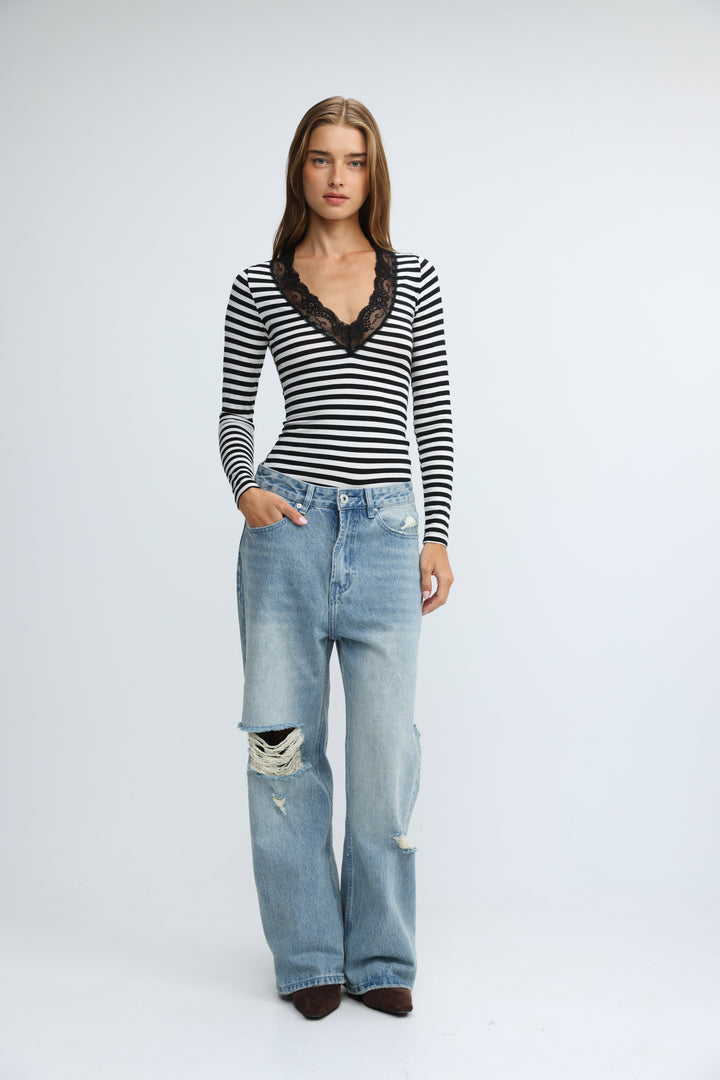 Mysterious black striped shirt with long sleeves and lace-trimmed v-neckline shown from the front