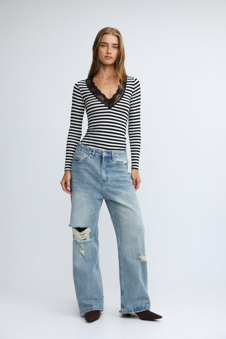 Black and white striped long-sleeve top with black lace v-neckline shown from the front