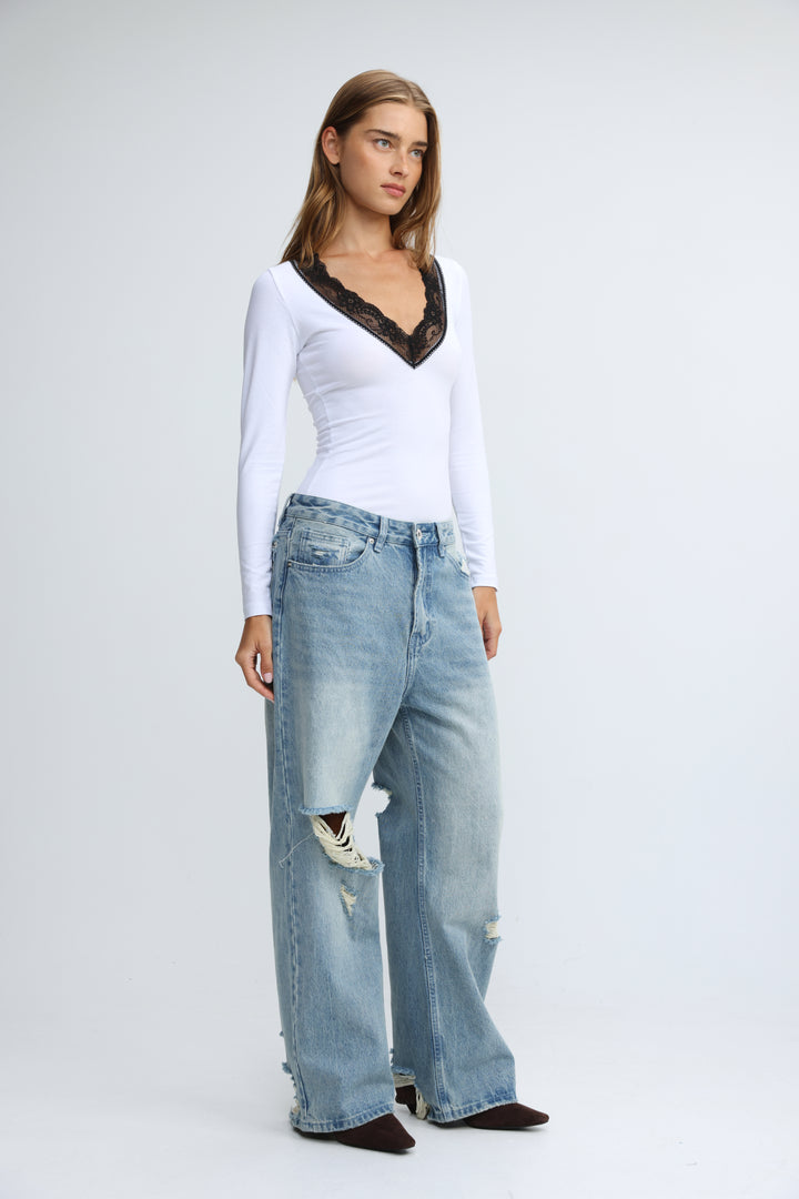 White long-sleeved shirt with black lace trim at the neckline shown from the front titled mysterious white shirt
