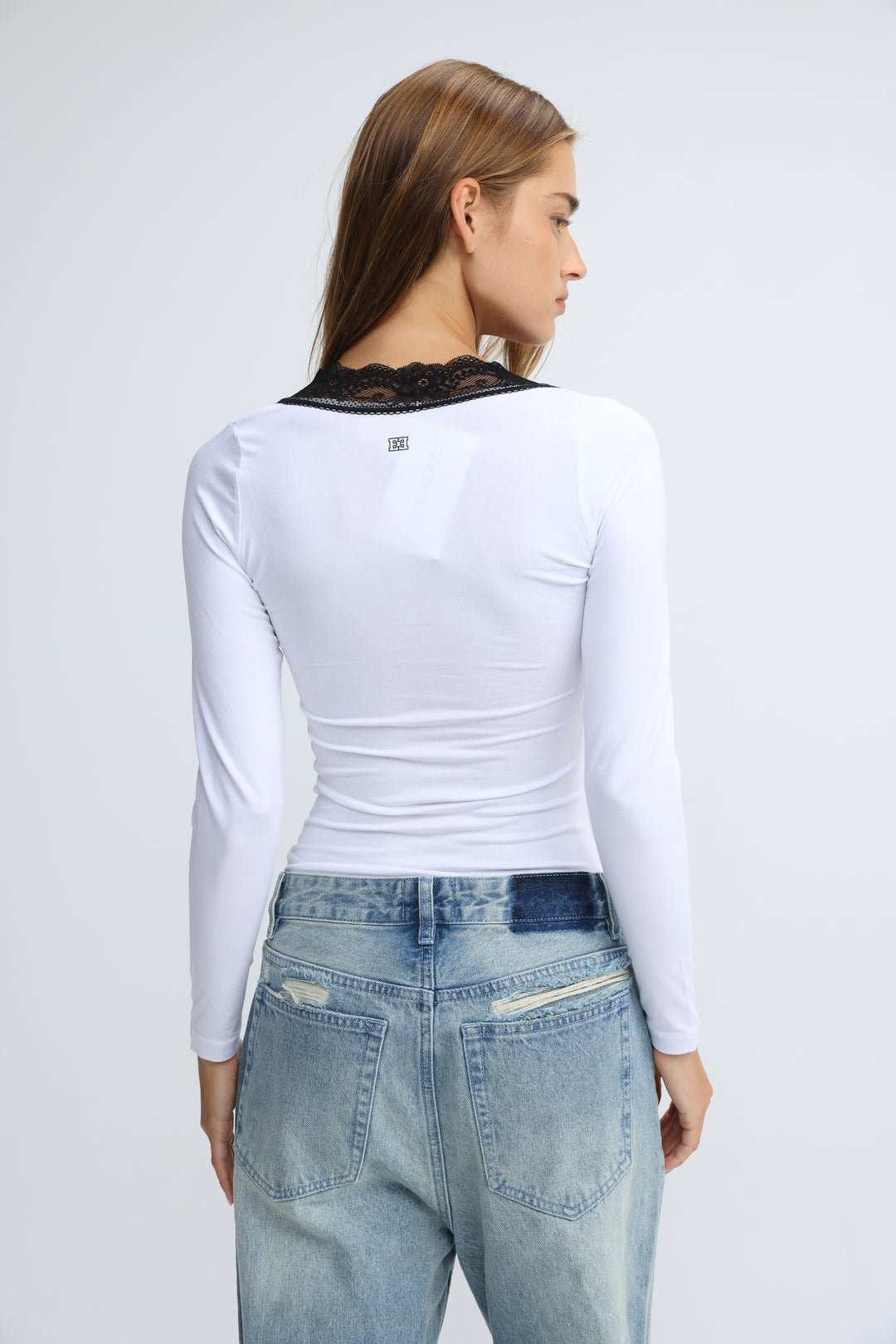 White long-sleeved shirt with black lace trim at the neckline shown from the front titled mysterious white shirt