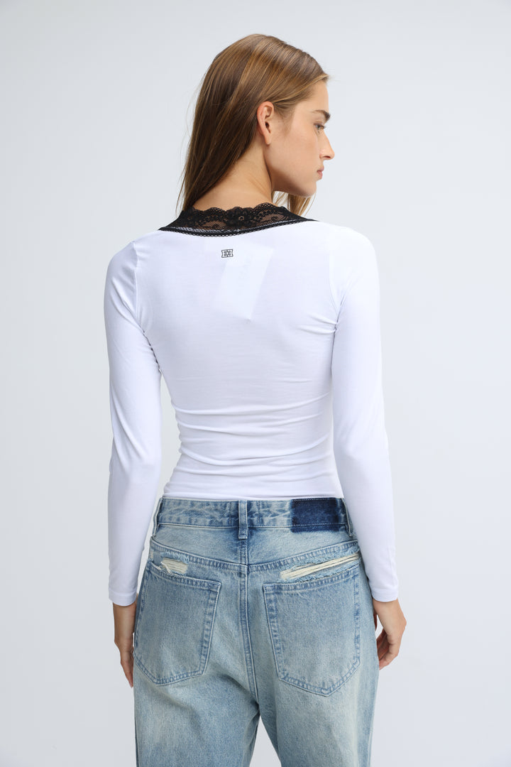 White long-sleeved shirt with black lace trim at the neckline shown from the front titled mysterious white shirt