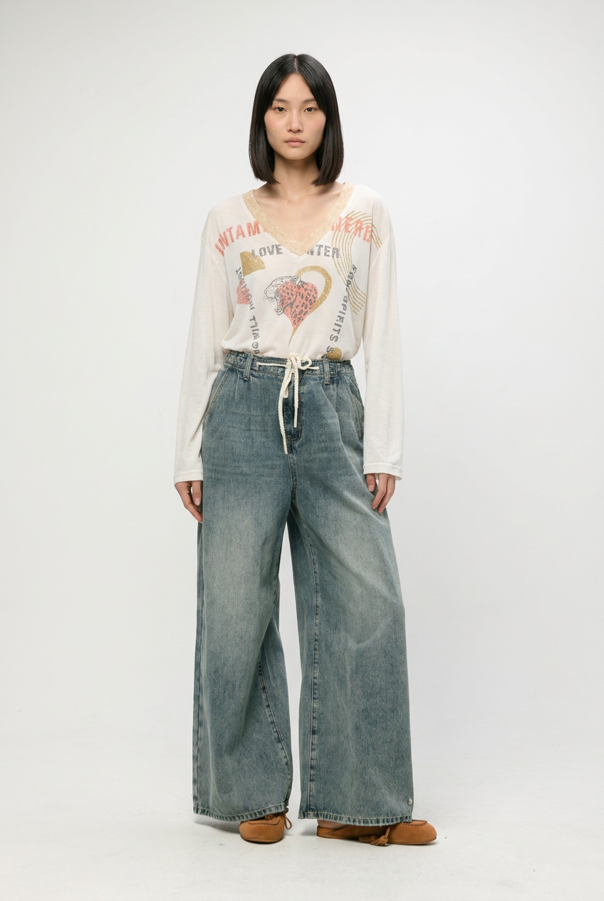 White long-sleeved v-neck graphic tee with colorful text and orange heart outline featured in star 461 blue denim collection