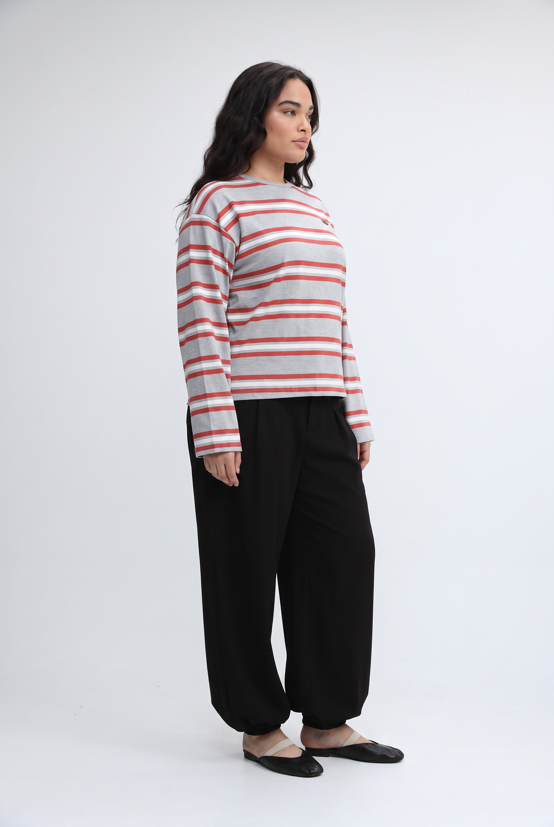 A woman wearing a Federer wine striped long-sleeved top with red and gray horizontal stripes paired with black pants