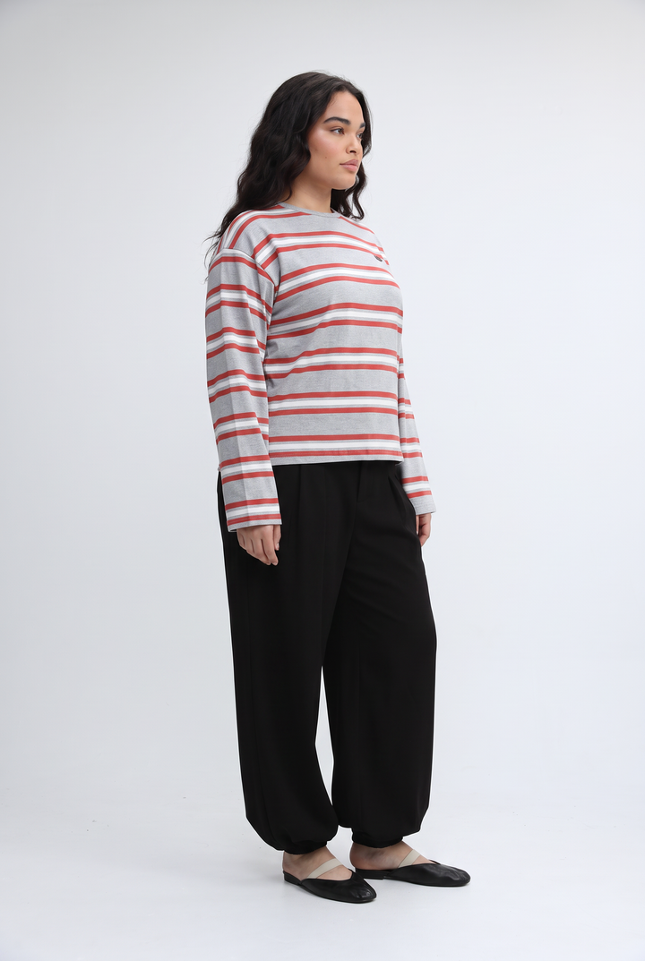 A woman wearing a Federer wine striped long-sleeved top with red and gray horizontal stripes paired with black pants