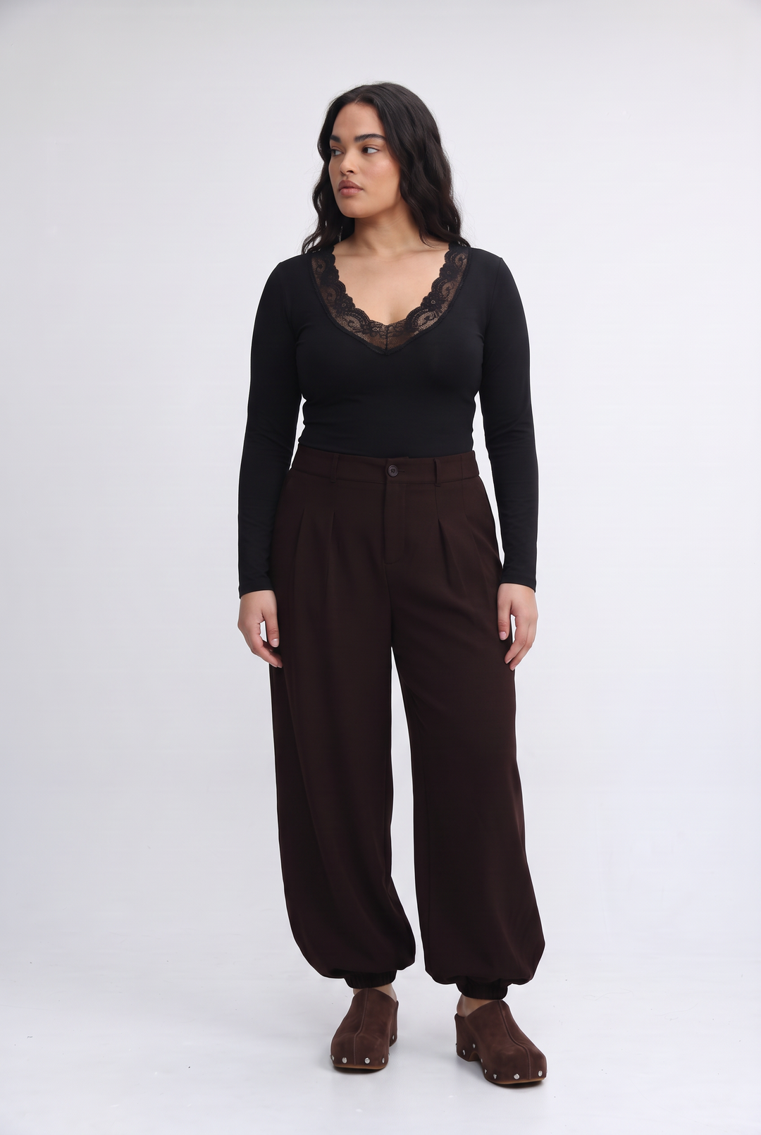 Black long-sleeved top with a dark lace-trimmed v-neckline shown from the front in the mysterious white shirt product