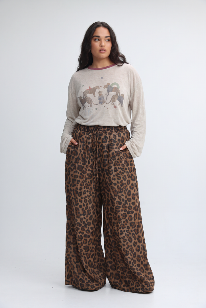Wide-leg cream leopard-print pants with elastic waistband in a flowing earth-toned fabric shown from the front