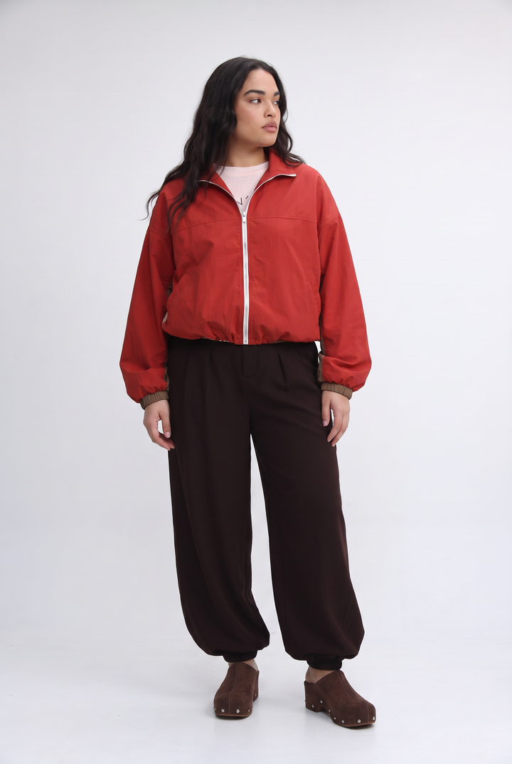 A vibrant red bomber jacket with a white zipper and ribbed cuffs shown from the front named madas red jacket