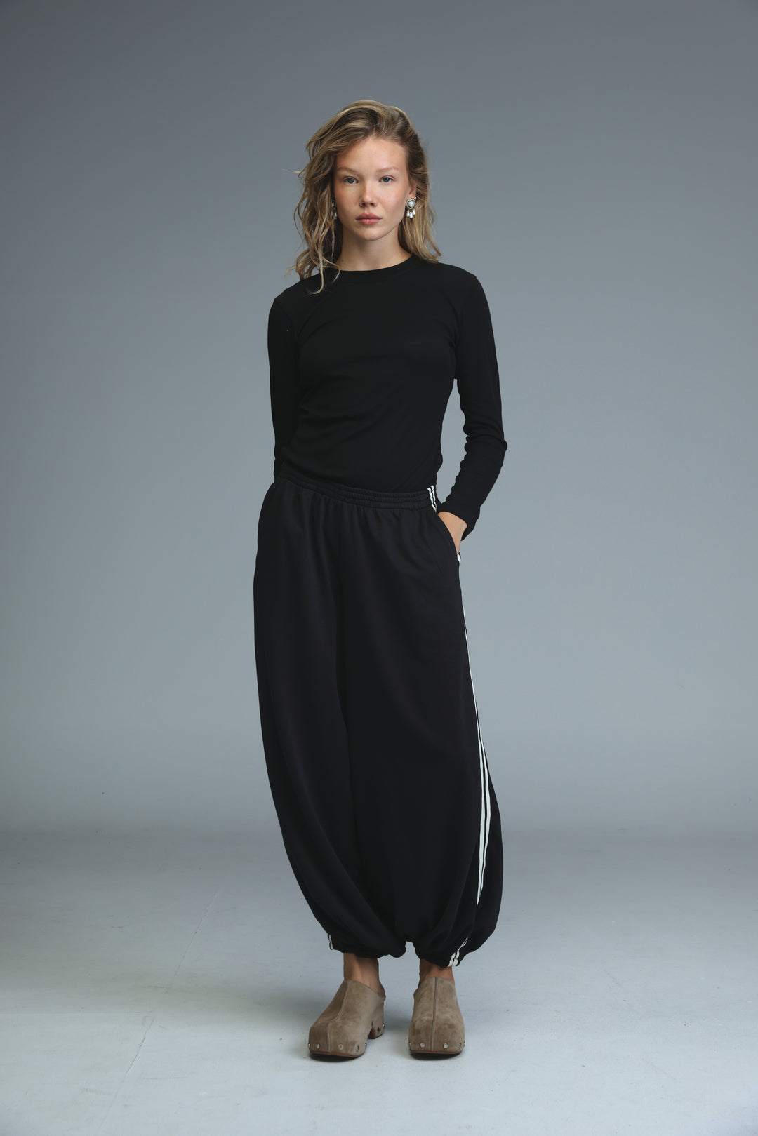 Ballooning black striped joggers paired with a black long-sleeved top with round neckline and side seam detailing