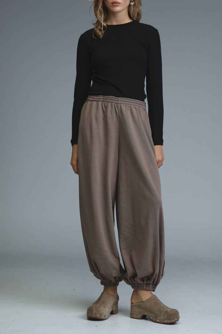 Ballooning brown striped joggers with loose fit and elastic waistband shown from the front