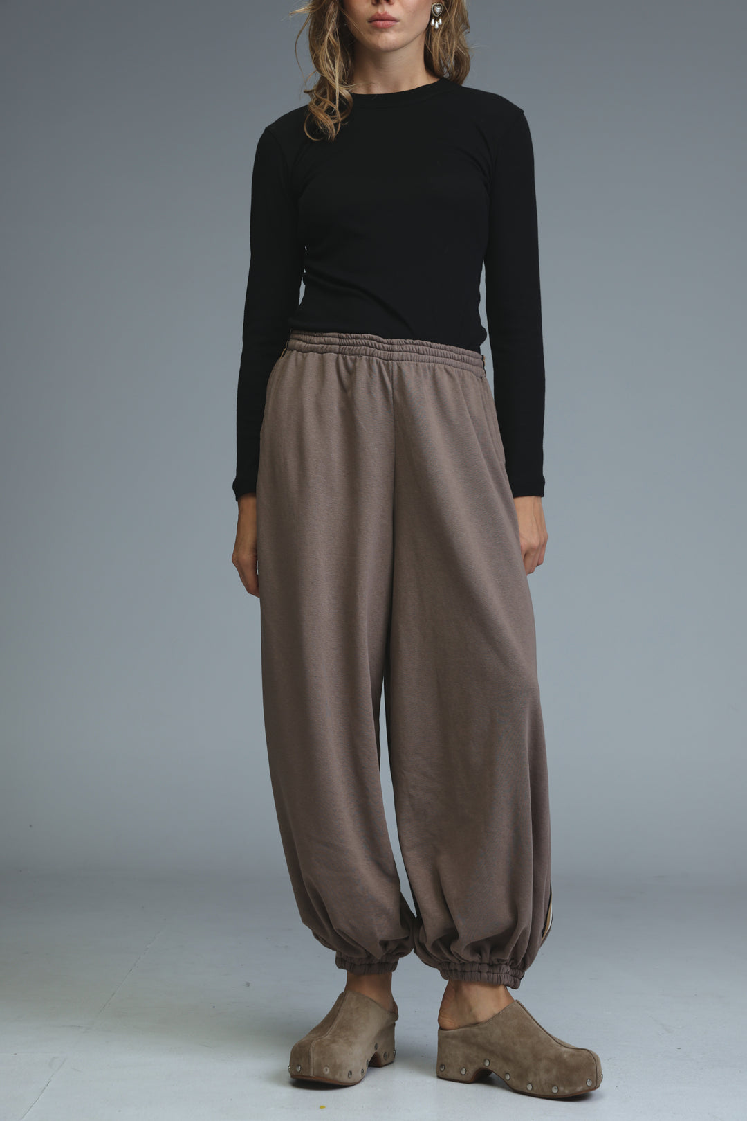 Ballooning brown striped joggers with loose fit and elastic waistband shown from the front