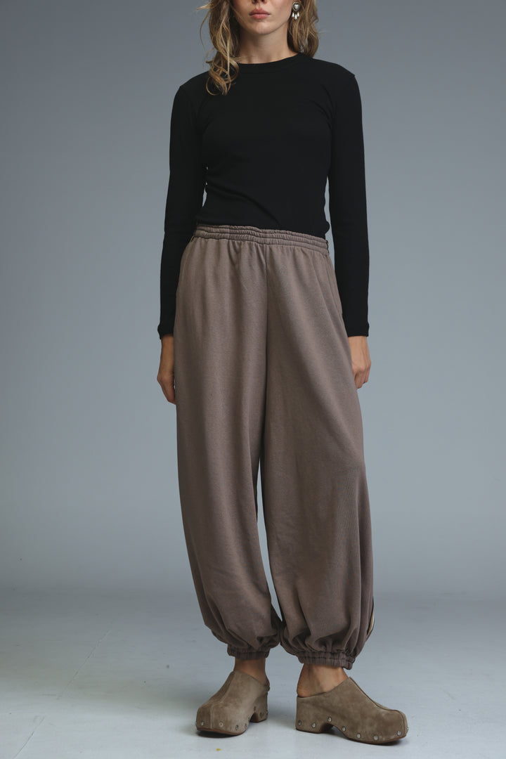 Ballooning brown striped joggers with loose fit and elastic waistband shown from the front