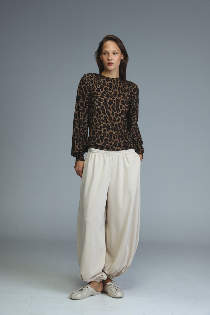 A front view of an LG leopard padded shirt in leopard print with long sleeves paired with cream pants