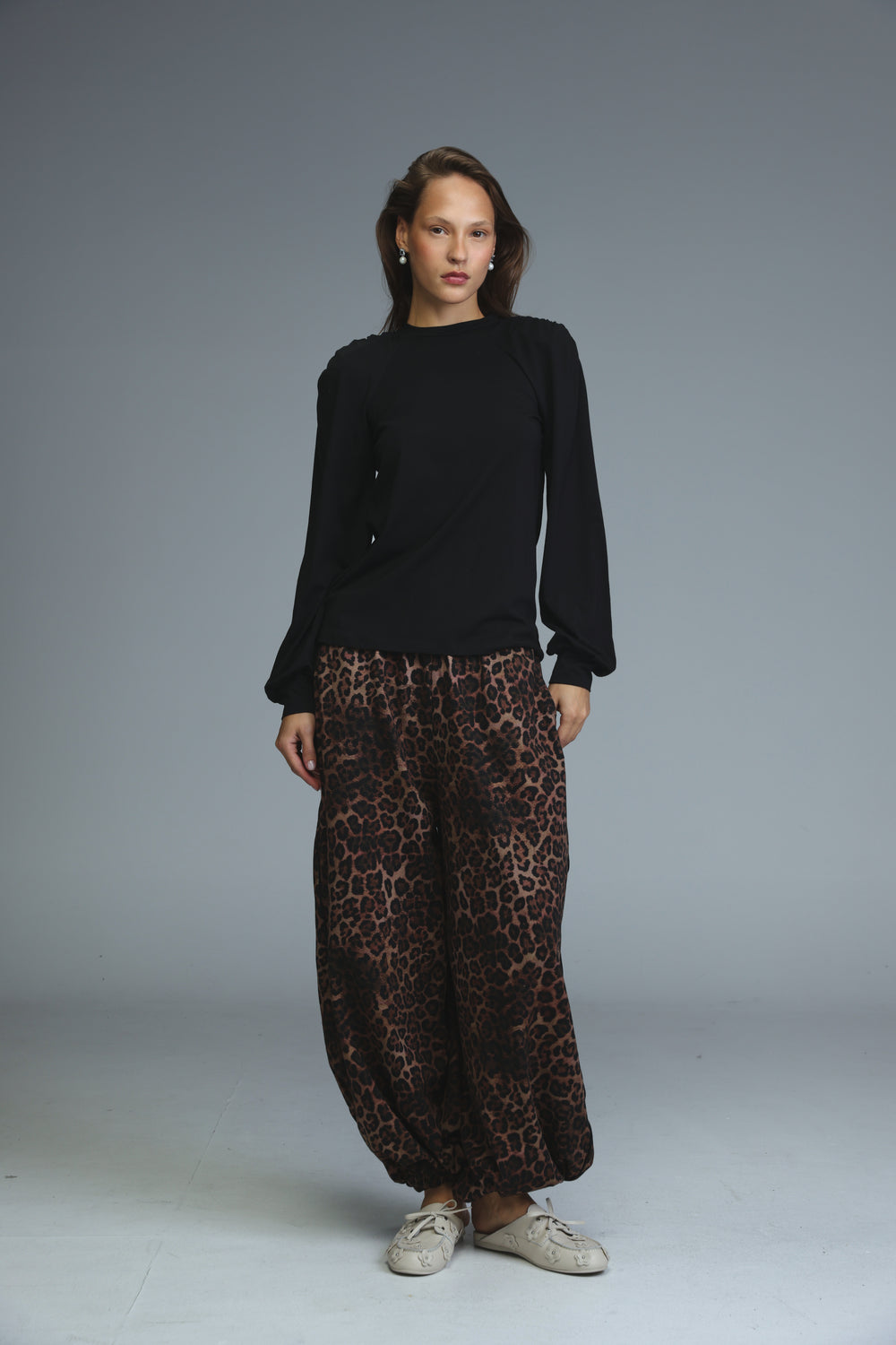 Black padded shirt with long sleeves ruffled cuffs and high neckline shown from the front