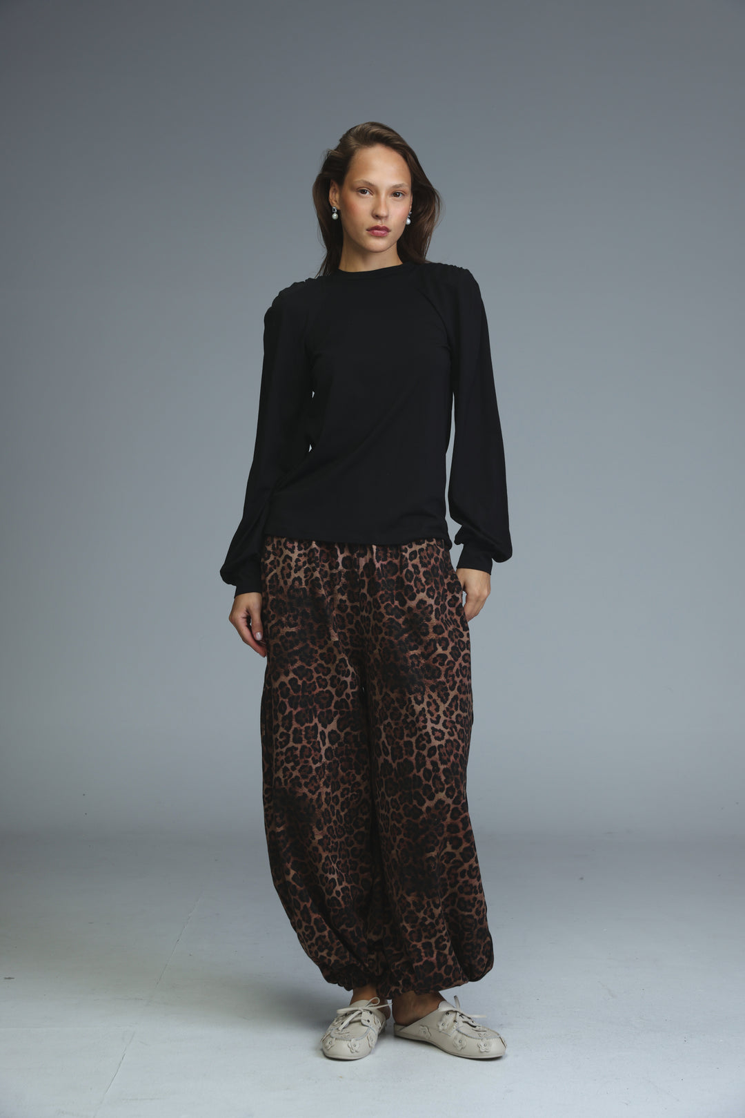 Black padded shirt with long sleeves ruffled cuffs and high neckline shown from the front