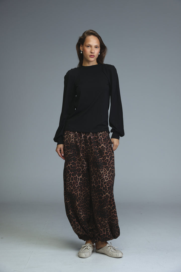 Black padded shirt with long sleeves ruffled cuffs and high neckline shown from the front