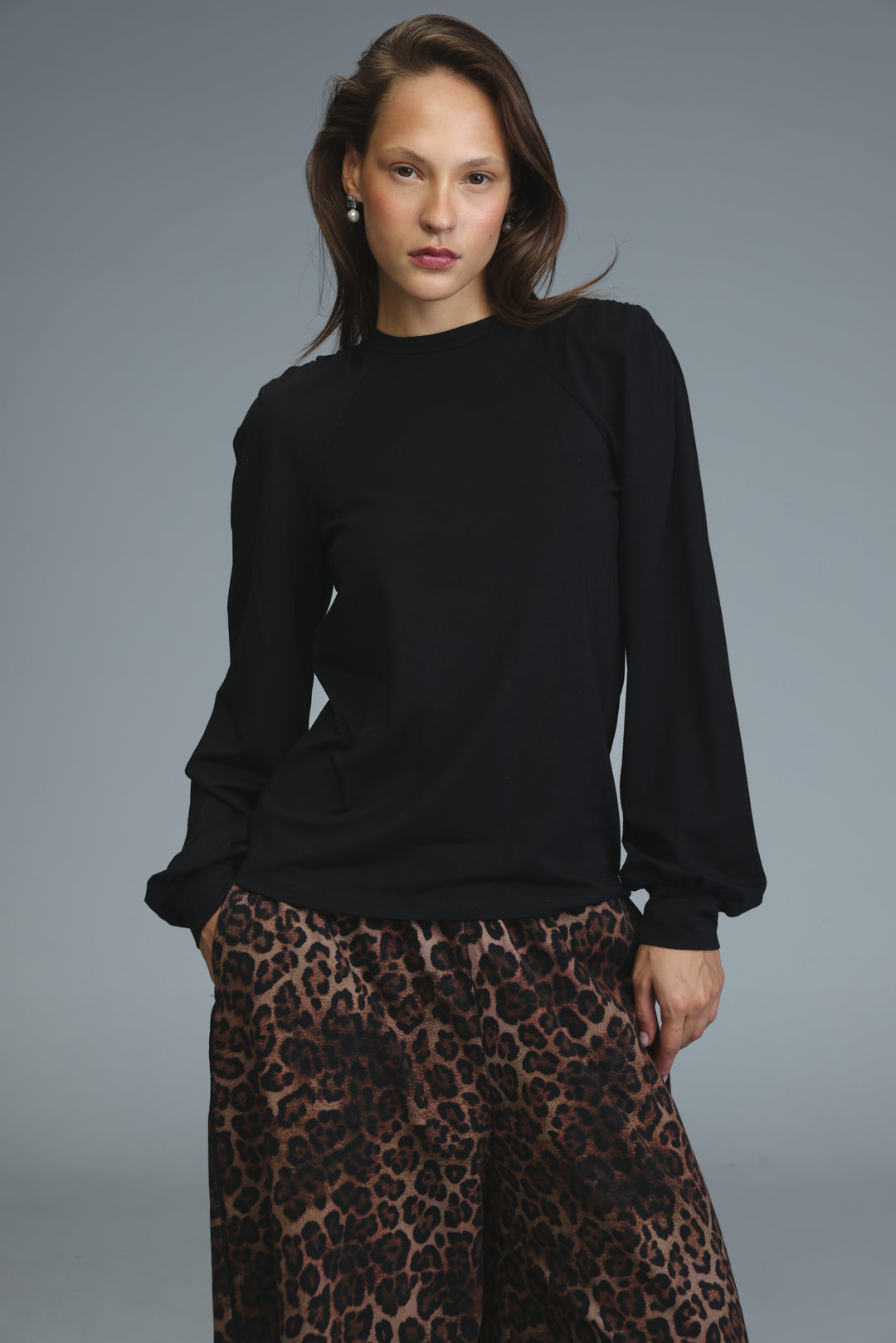 Black long-sleeved padded shirt with a soft, slightly loose fit and subtle ribbed cuffs shown from the front