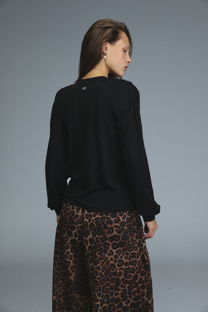 Black long-sleeved padded shirt with a subtle logo on the back neckline shown from the back view