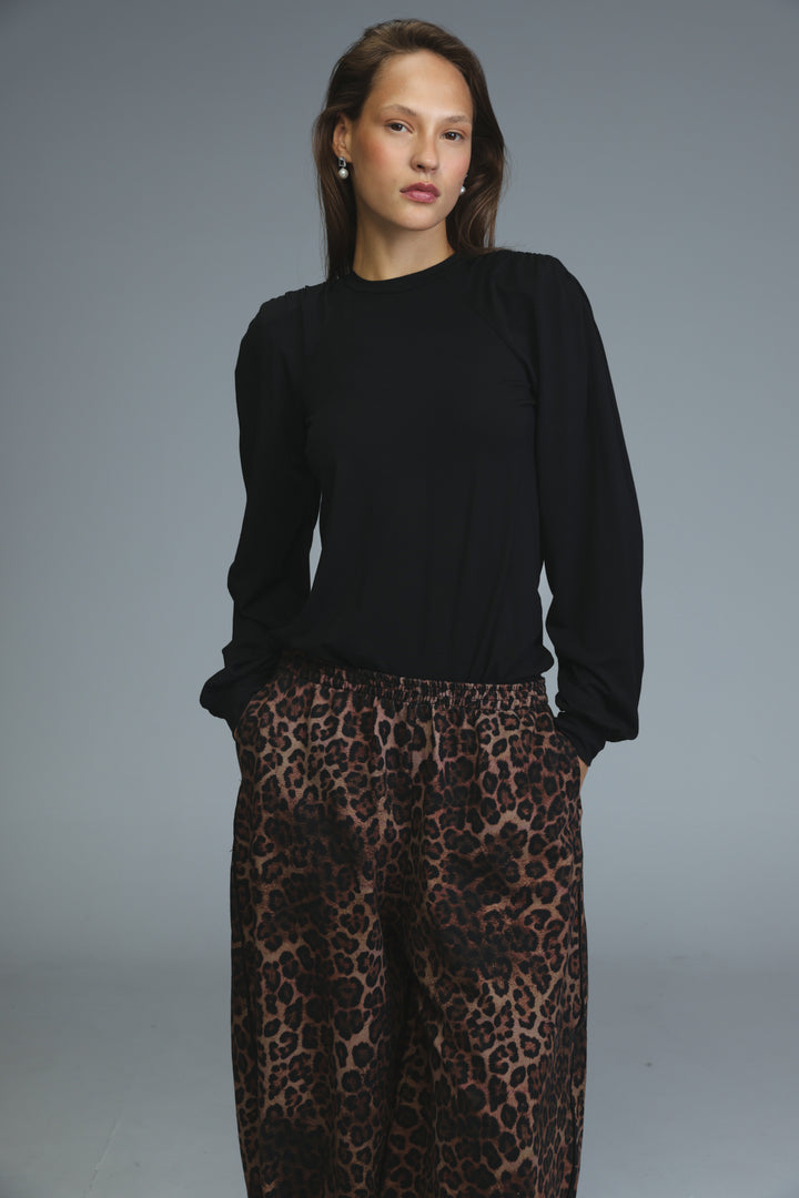 Black padded shirt with long sleeves, puffed shoulders, and high neckline shown from the front