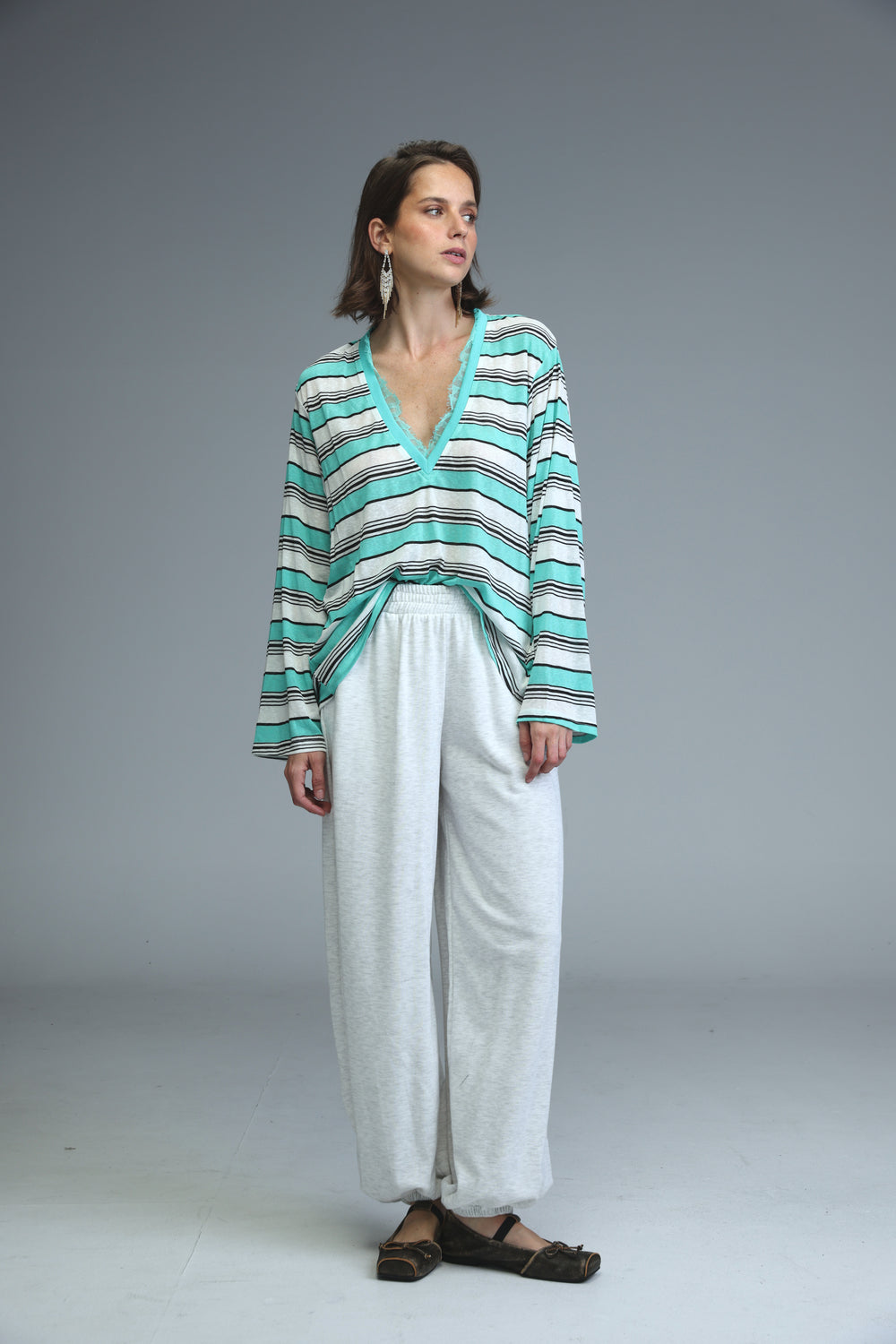 A front view of a long-sleeved glow mint striped shirt with teal and black horizontal stripes and a v-neck
