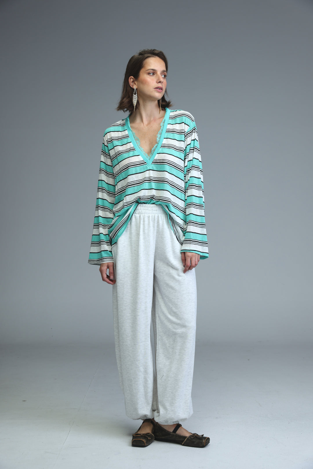 A front view of a long-sleeved glow mint striped shirt with teal and black horizontal stripes and a v-neck