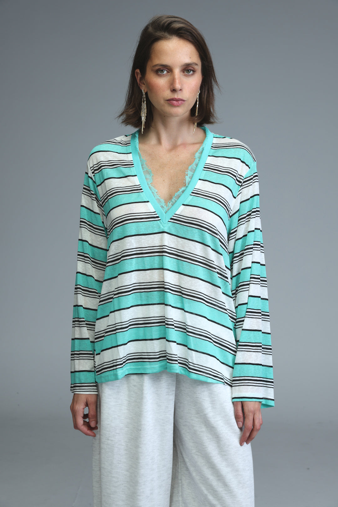 Glow mint striped women’s long-sleeved v-neck top with horizontal mint green white and black stripes front view