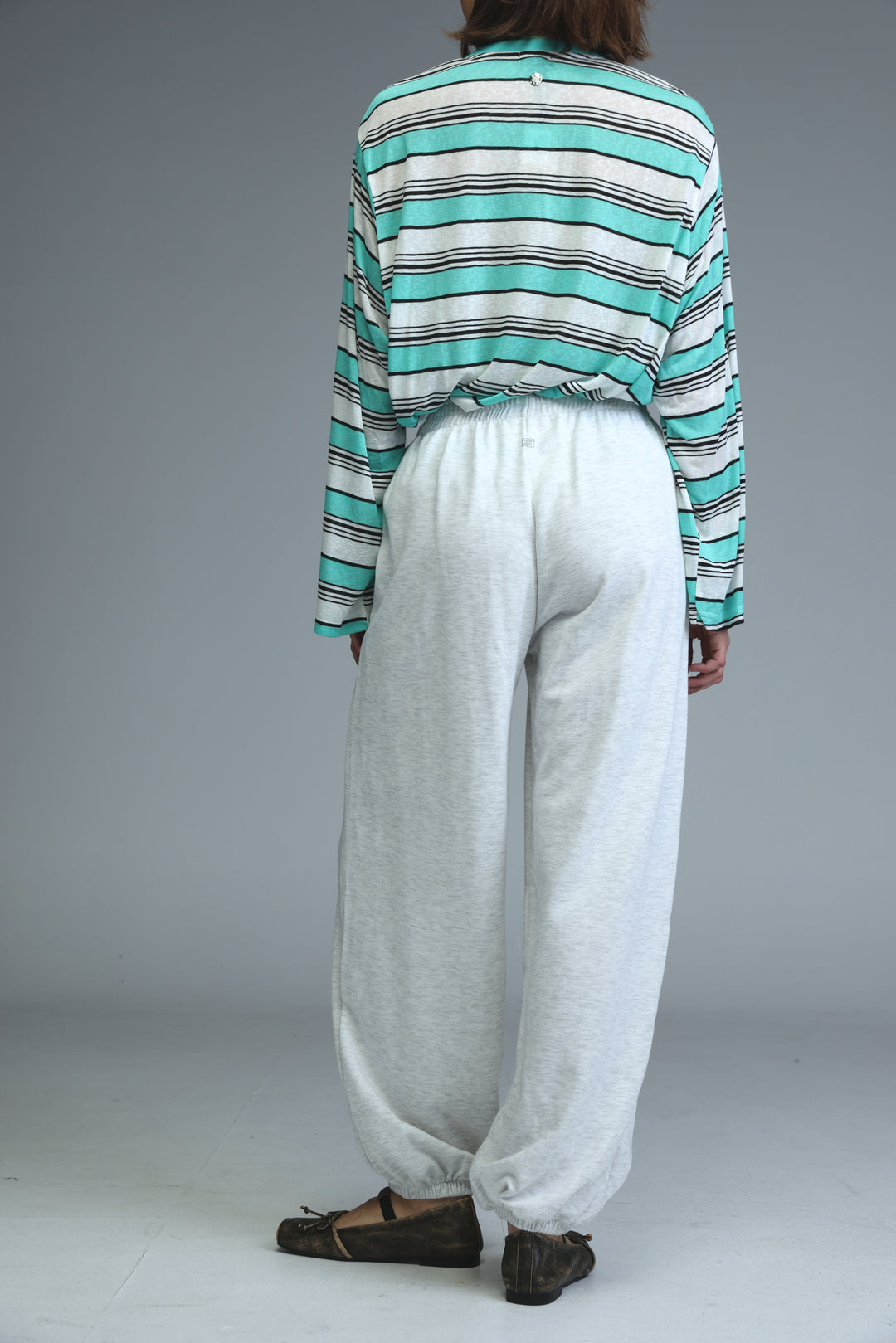 Light grey joggers featuring a loose fit and elastic cuffs visible from the front view