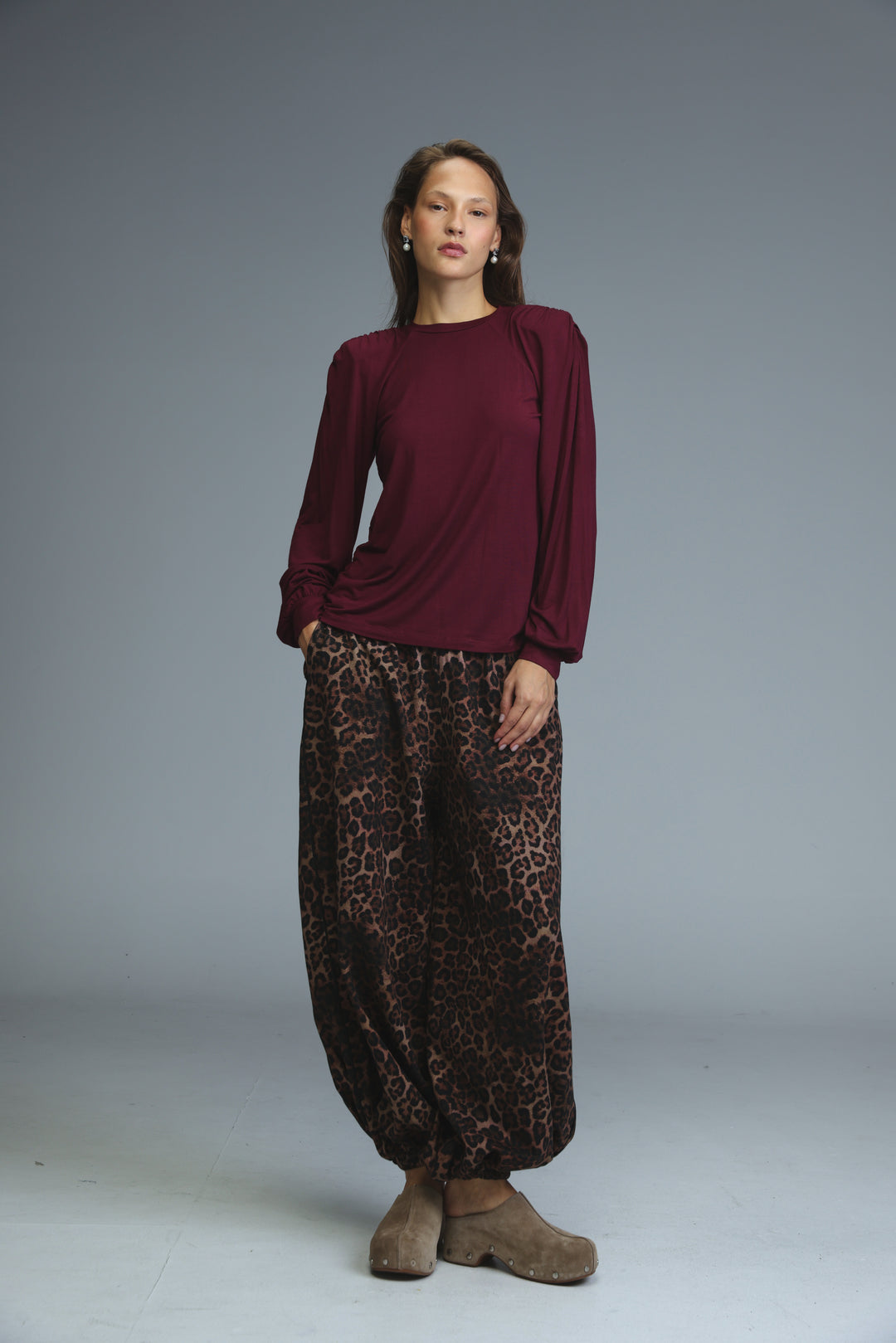 A woman wearing a maroon LG wine padded shirt with puffed shoulders shown from the front
