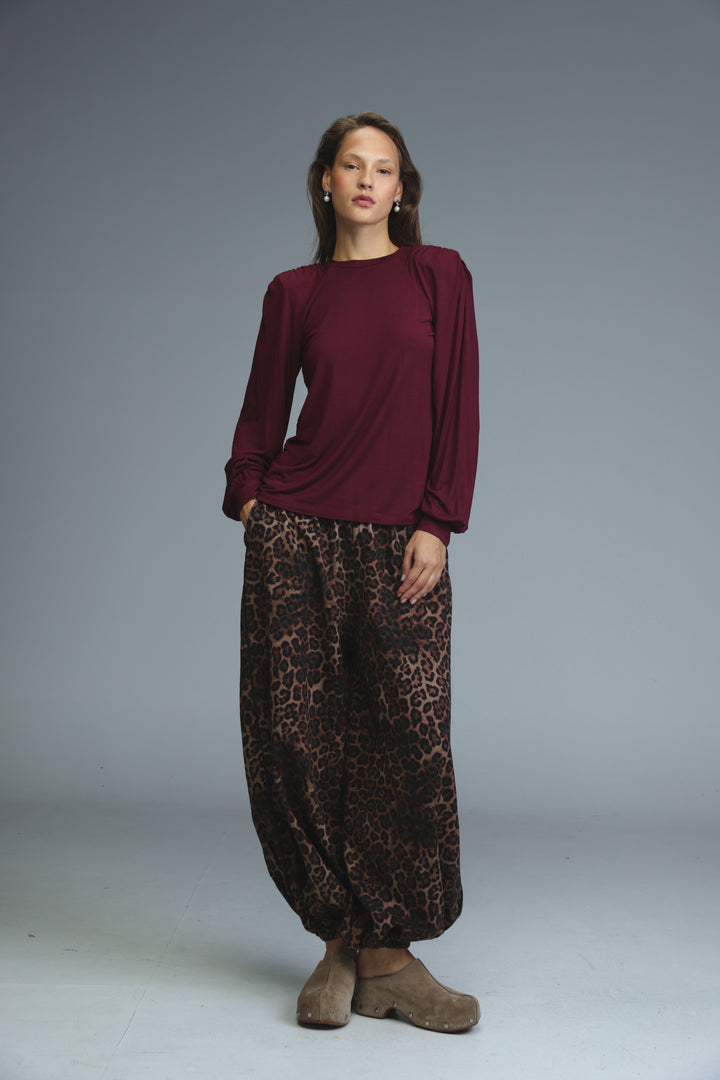 A woman wearing a maroon LG wine padded shirt with puffed shoulders shown from the front