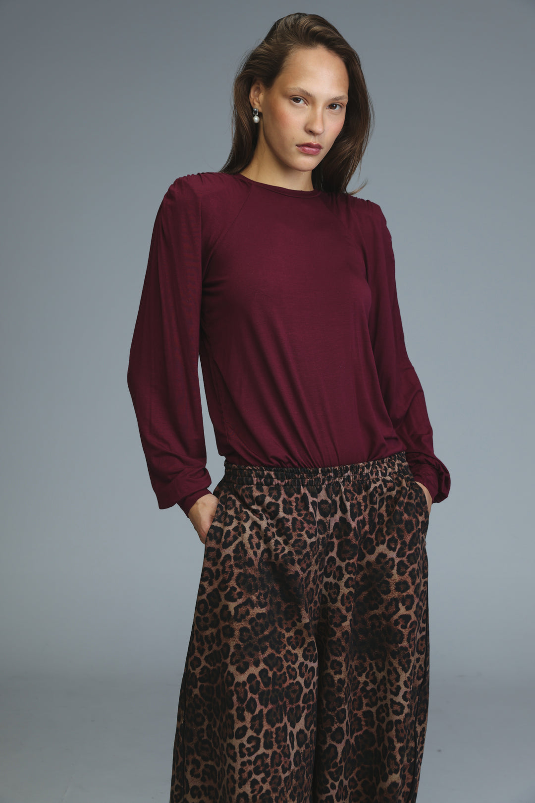 Maroon long-sleeved blouse with relaxed fit and gathered shoulder detailing shown from the front