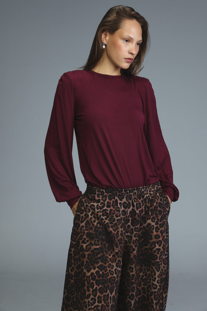 Burgundy long-sleeved wine padded shirt with round neckline and gathered fabric at the shoulders front view