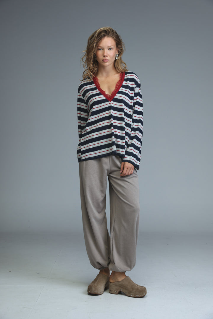 Glow blue striped shirt front view featuring navy and white stripes with a red lace-trimmed v-neck long sleeve sweater