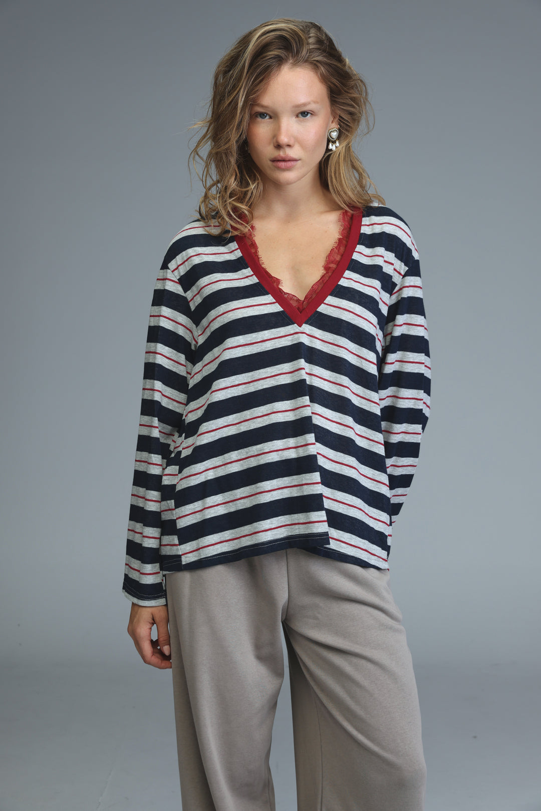 Glow blue striped shirt front view navy and white long-sleeved top with red lace-trimmed v-neck