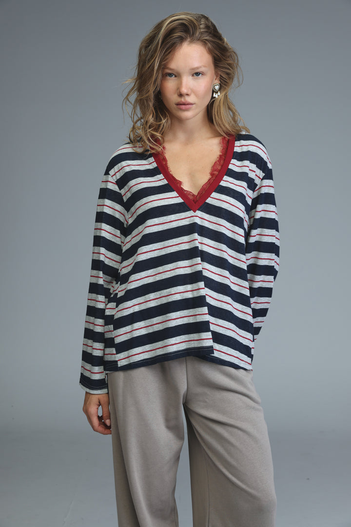 Glow blue striped shirt front view navy and white long-sleeved top with red lace-trimmed v-neck