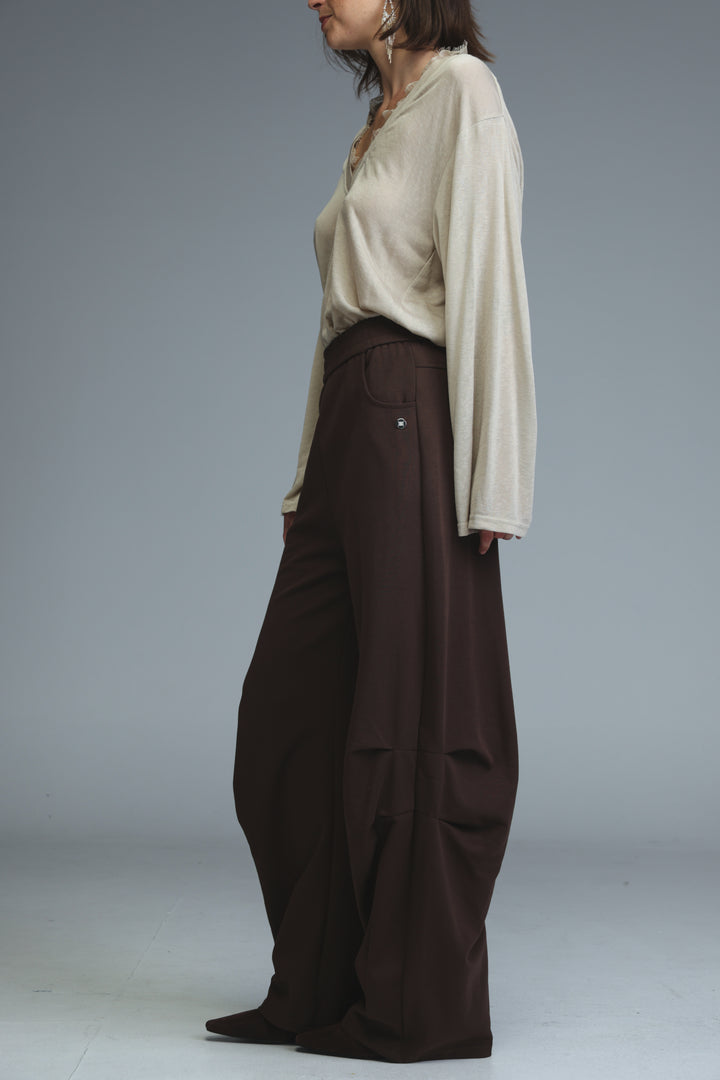 The 646 brown joggers feature wide-leg cut, subtle pleats, and a small metallic button detail on the side seam