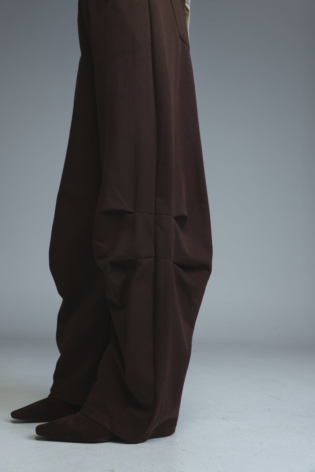Dark brown 646 joggers with wide legs, relaxed fit, and subtle front pleats shown from the front view
