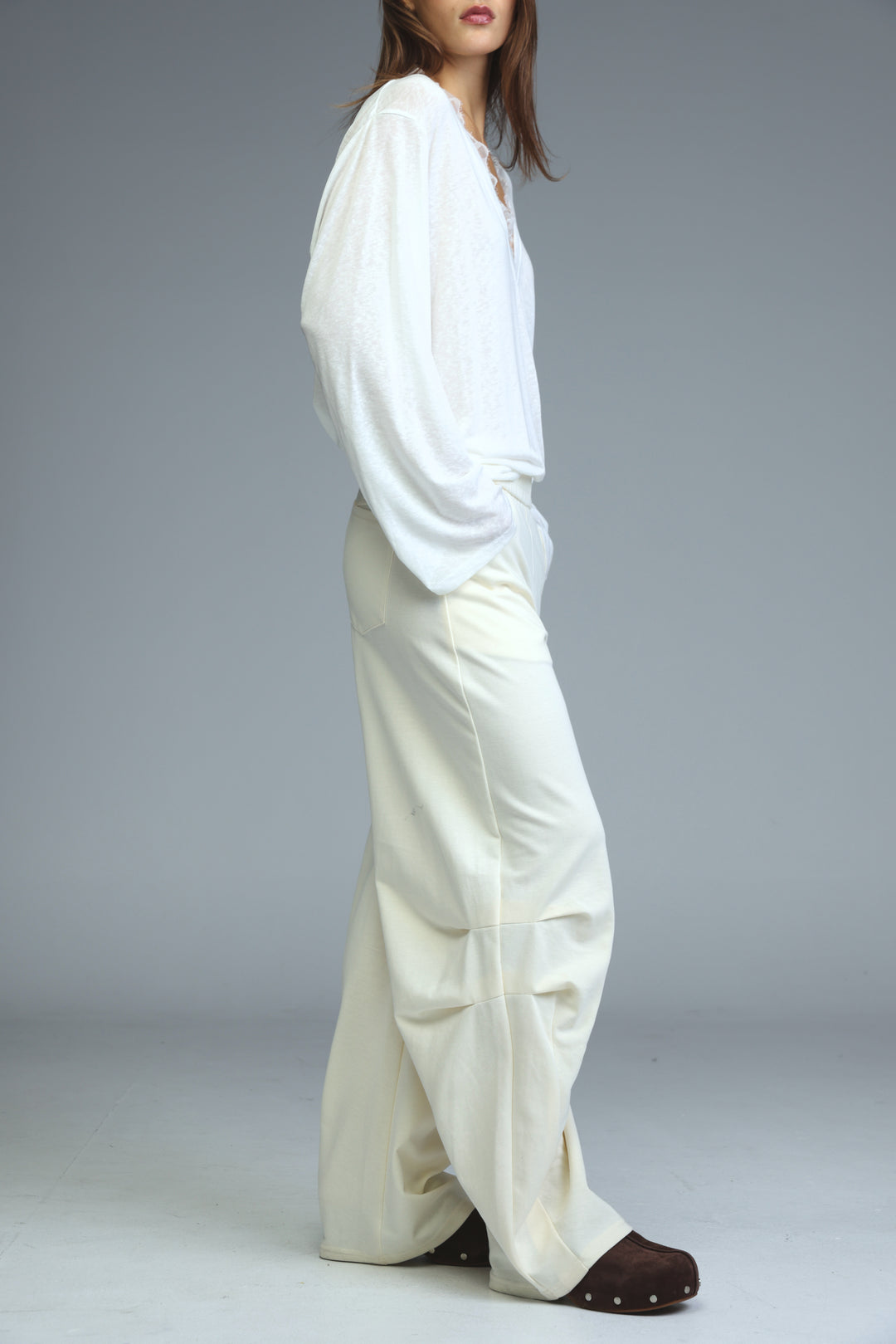 White flowing blouse with voluminous sleeves paired with cream joggers shown from the front