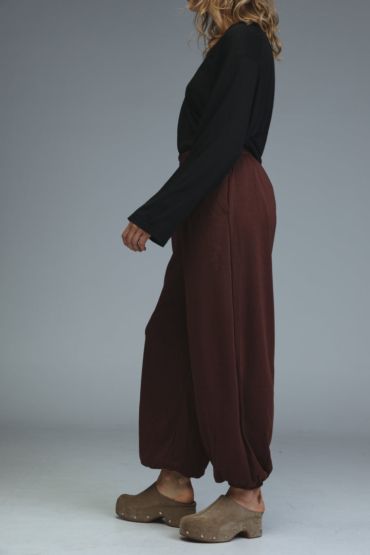 Brown joggers with wide-leg relaxed silhouette and elasticated cuffs shown from the front view