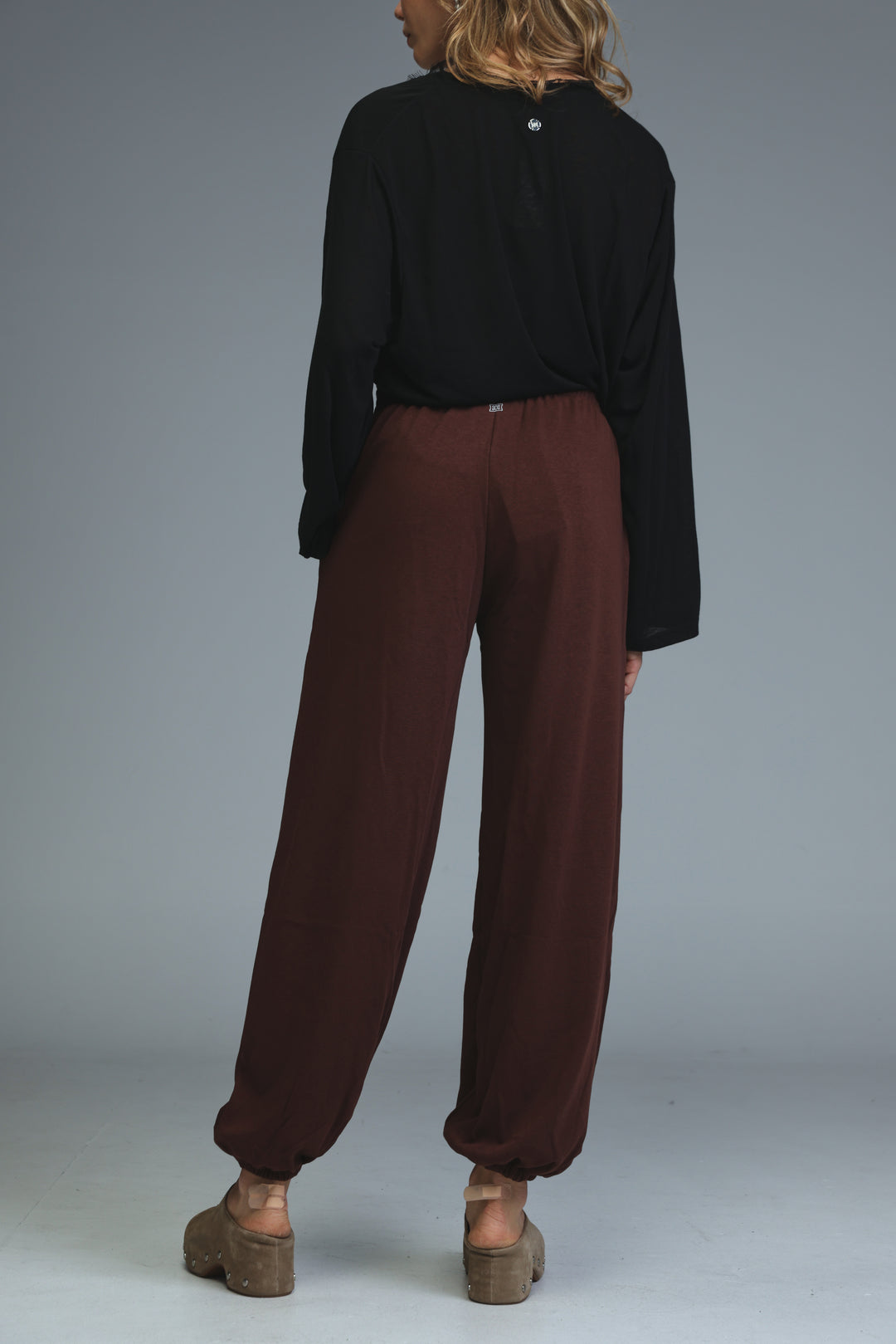 Brown joggers with wide legs, relaxed fit, and elasticated cuffs shown from the front view