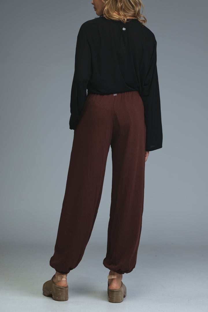 Brown joggers with wide legs, relaxed fit, and elasticated cuffs shown from the front view