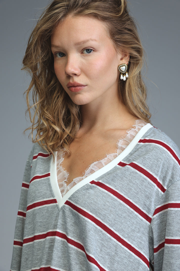 Glow grey striped long-sleeved shirt with red stripes and white lace trim at the neckline, front view