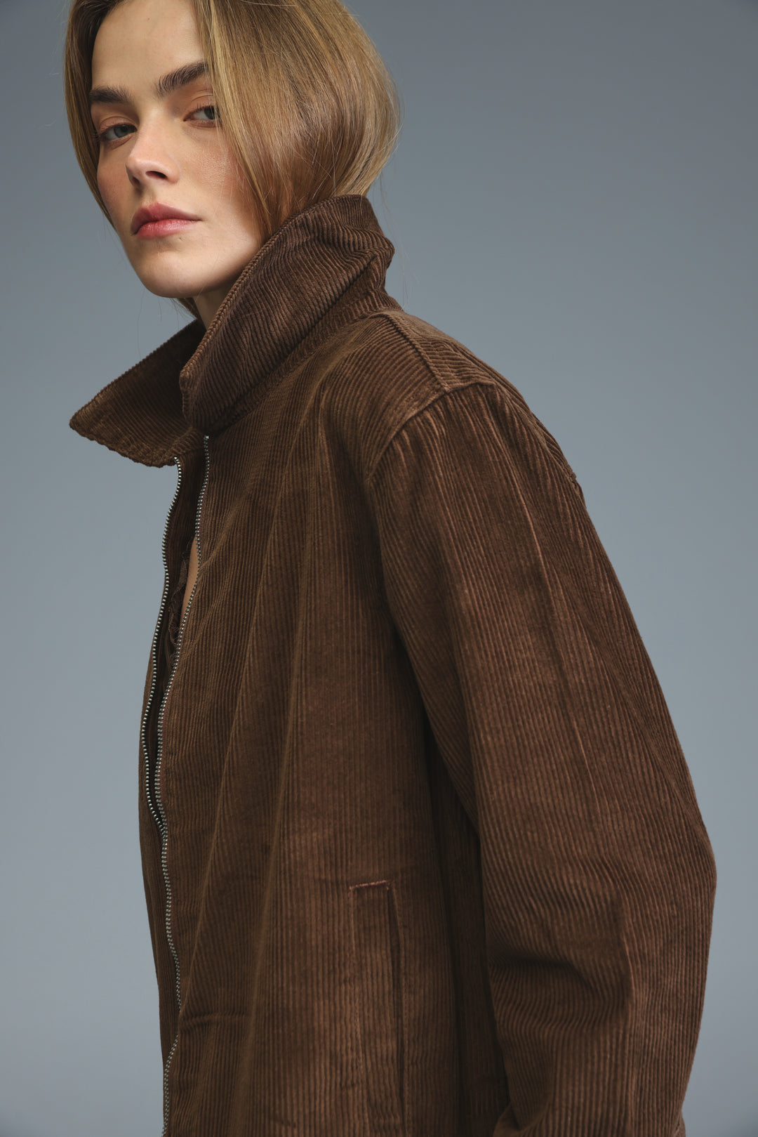 Brown corduroy jacket with a high collar and front zipper shown from the front