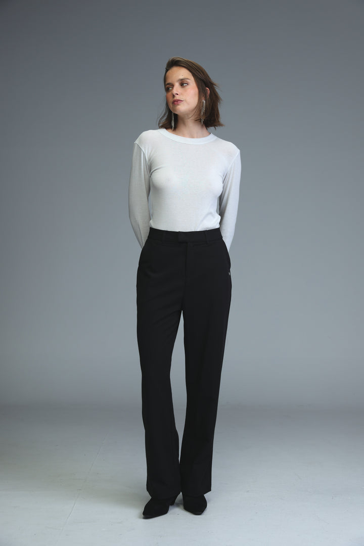 Mid rise tailored black bottoms with a sleek white long-sleeved top featuring a rounded neckline and subtle ribbed texture
