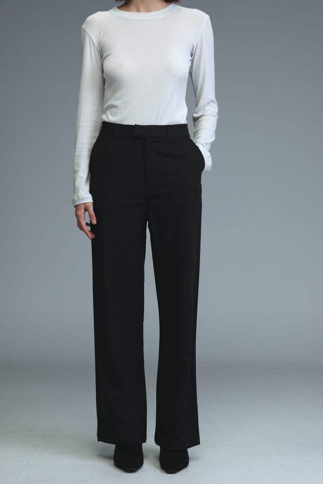 Mid rise tailored black wide-leg trousers with a sleek fit and subtle front pleats shown from the front