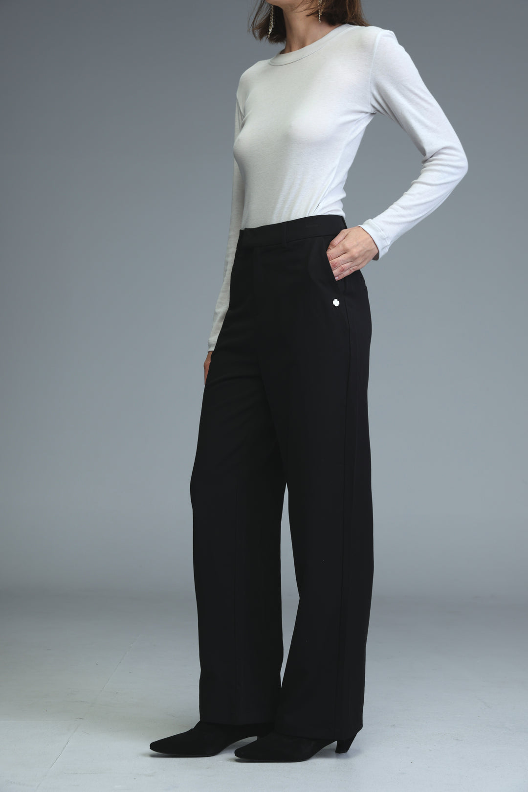 Mid rise tailored black wide-leg trousers with a sleek fit and subtle side button detailing front view