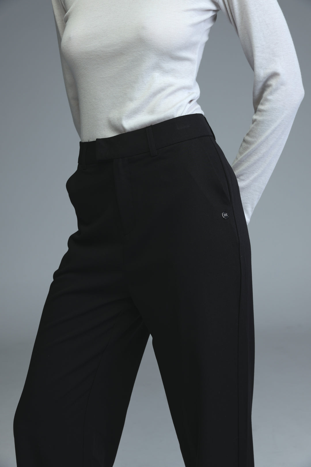 Black tailored trousers with mid rise, straight-leg cut, and subtle side seam detailing shown from the front view