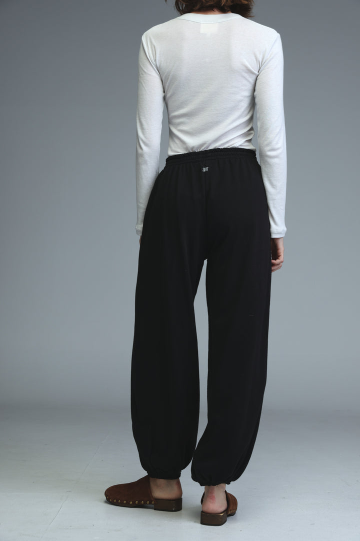 Black high-waisted wide-leg joggers with elastic cuffs and subtle logo at the front waistband